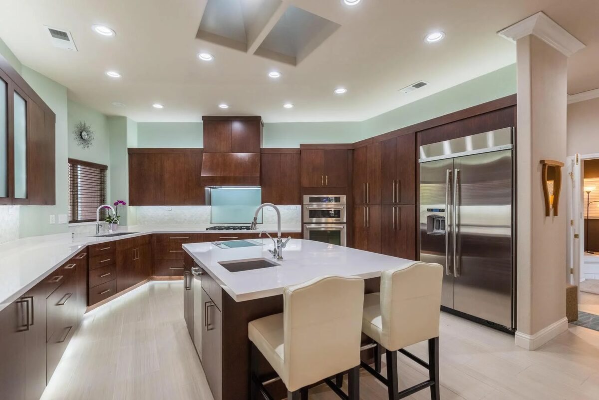 Contemporary kitchen with curved island and wood cabinetry