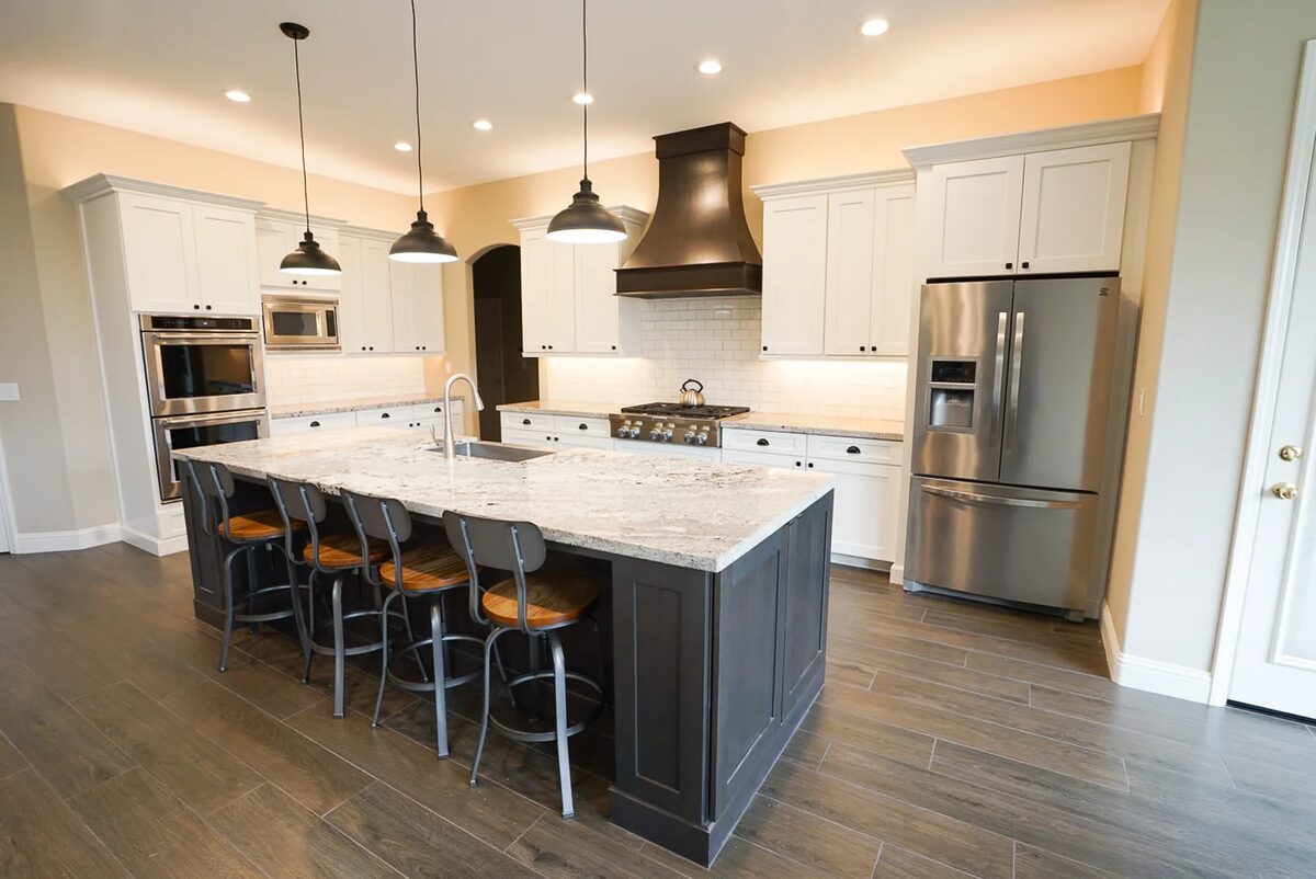 White kitchen with dark island and pendant lighting