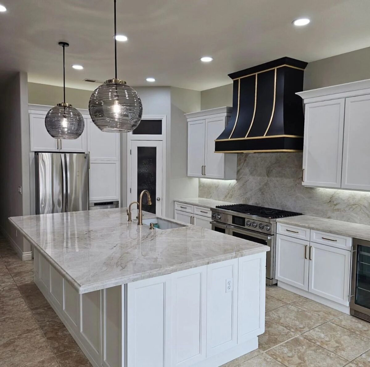 White kitchen with black range hood and marble backsplash