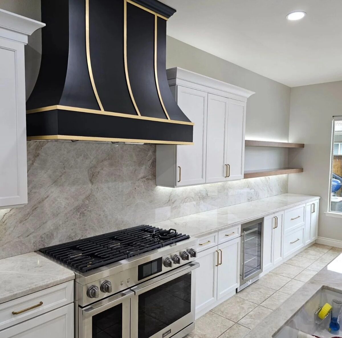 White kitchen with black and brass range hood