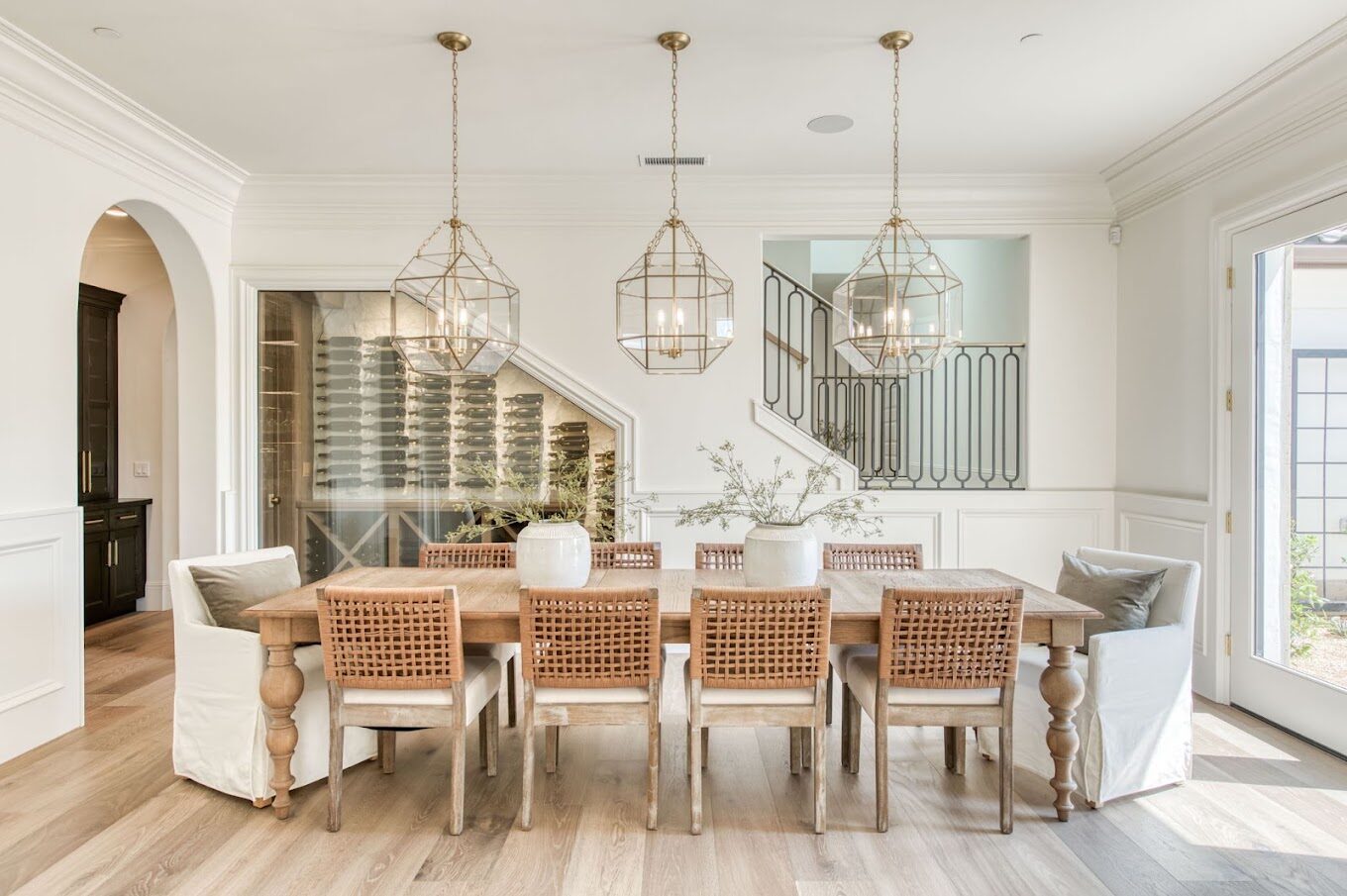 Dining room with pendant lighting beside custom kitchen