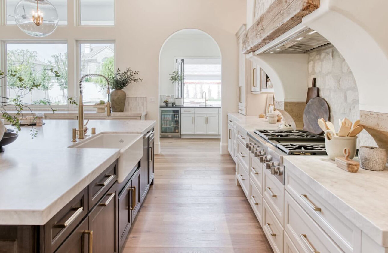 White custom kitchen with arched range alcove and quartz island